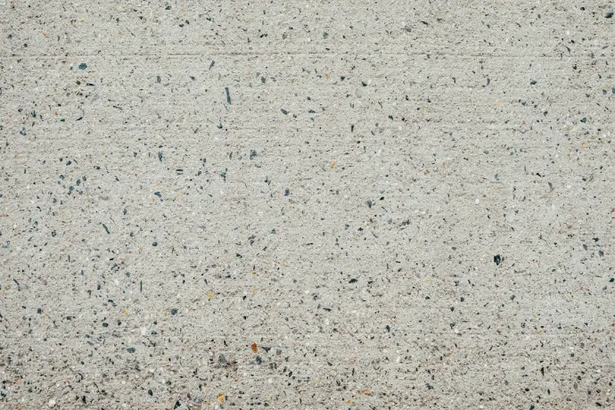 a close up of a cement surface with small black dots